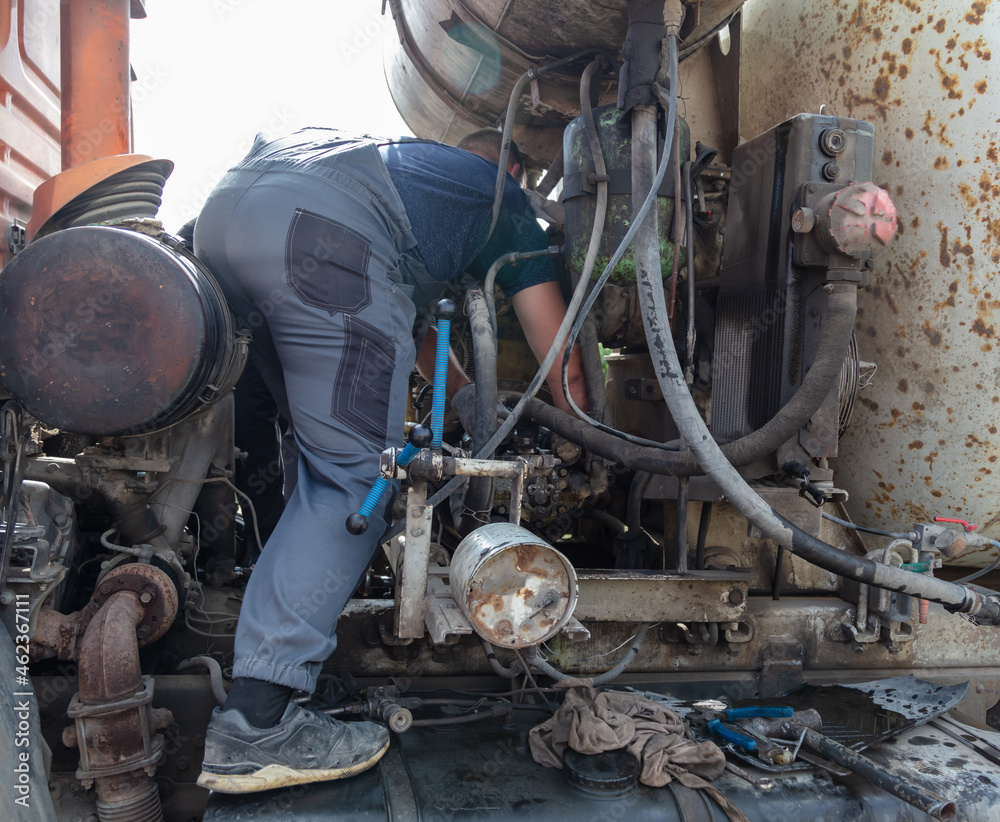 Fototapeta premium Worker repairing an engine in a truck
