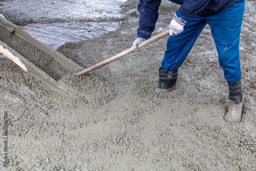 Workers level out the concrete mix at a construction site. Workers level out the concrete mix at a construction site.