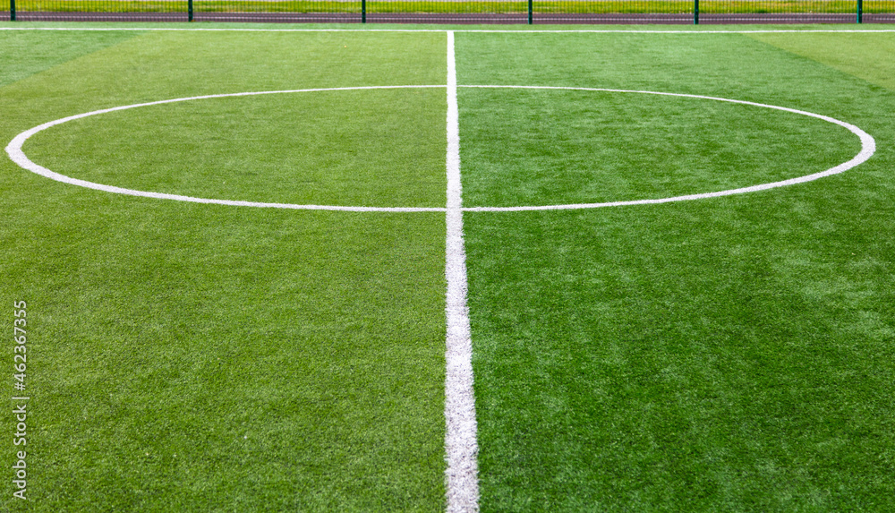 Obraz premium White circle on green grass on a soccer field.