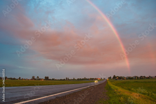 stormy sky with rainbow over the road © makam1969
