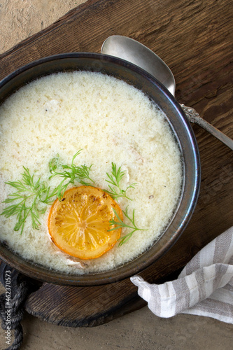 bowl of Greek chicken avgolemono soup on the table photo