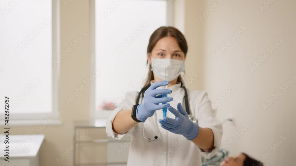Doctor standing near pregnant woman with syringe in hands