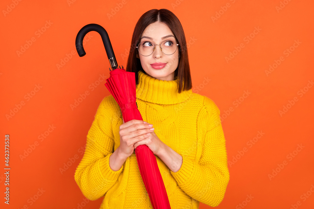 Photo of young woman happy positive smile dream look empty space hold parasol fall isolated over orange color background Photo of young woman happy positive smile dream look empty space hold parasol fall isolated over orange color background
