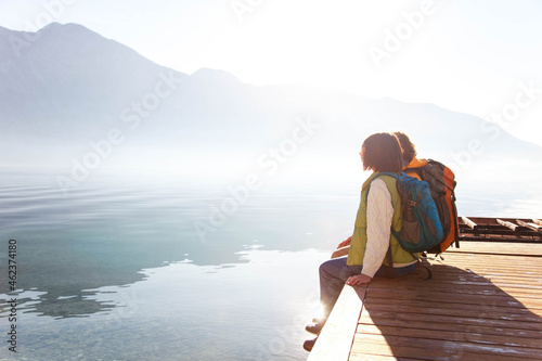 Travelers sitting by sea, mountains. Couple in love relaxing