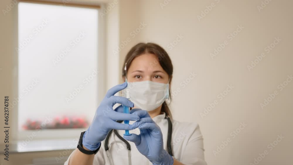 Doctor's hands hold syringe with vaccine at hospital. Health and medical concepts. Scientist fills ebola vaccine from syringe. Doctor microbiologist researcher scientist in laboratory Doctor's hands hold syringe with vaccine at hospital. Health and medical concepts. Scientist fills ebola vaccine from syringe. Doctor microbiologist researcher scientist in laboratory