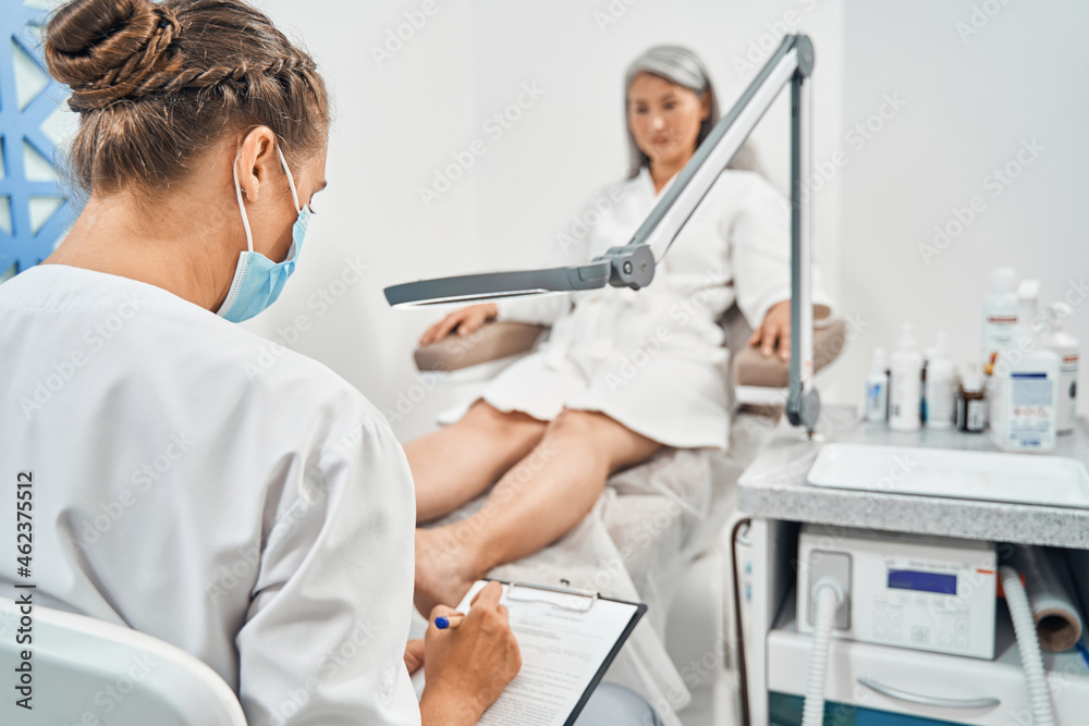 Obraz premium Silhouette of woman looking at her podologist