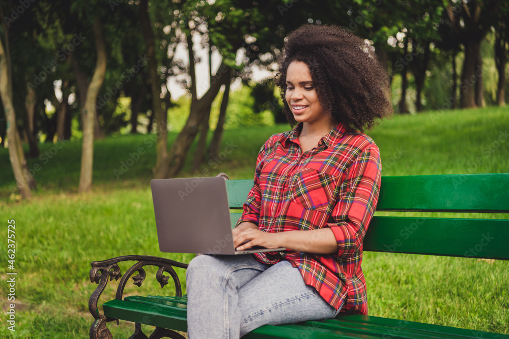 Photo portrait woman sitting on bench in city park in summer working on computer remotely Photo portrait woman sitting on bench in city park in summer working on computer remotely