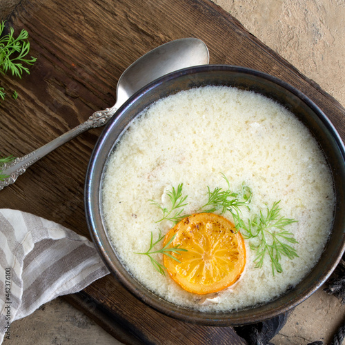 bowl of Greek chicken avgolemono soup on the table photo