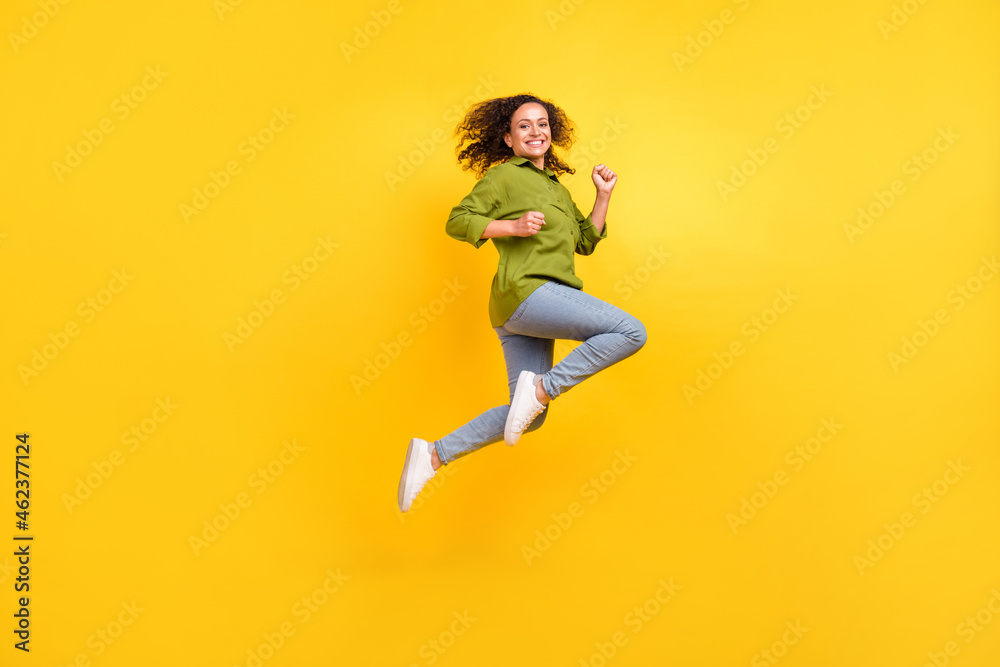Photo of beautiful funky funny positive stylish woman dressed green shirt jumping high running smiling isolated yellow color background