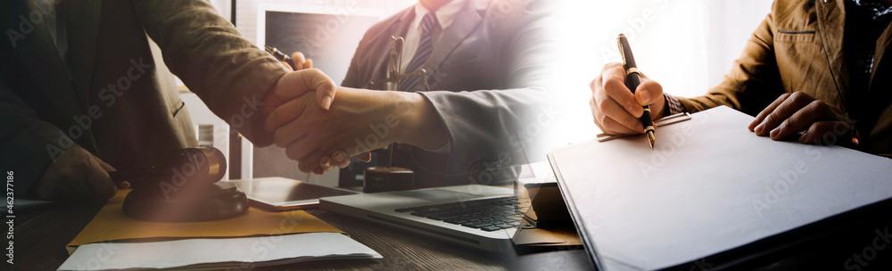 Fototapeta premium Business and lawyers discussing contract papers with brass scale on desk in office. Law, legal services, advice, justice and law concept picture with film grain effect