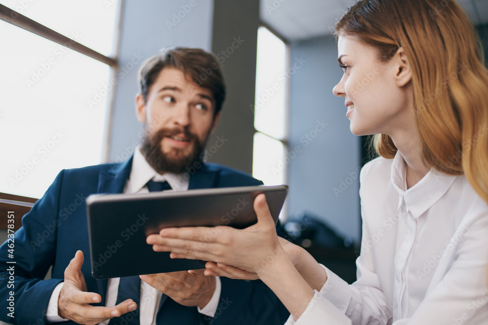 man and woman in business suits communicate with the tablet managers professionals man and woman in business suits communicate with the tablet managers professionals