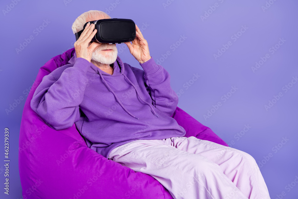 Profile side photo of aged man wear virtual reality glasses fantasy future game player isolated over violet color background Profile side photo of aged man wear virtual reality glasses fantasy future game player isolated over violet color background