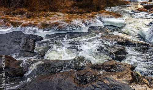 Fast river with ice in late autumn