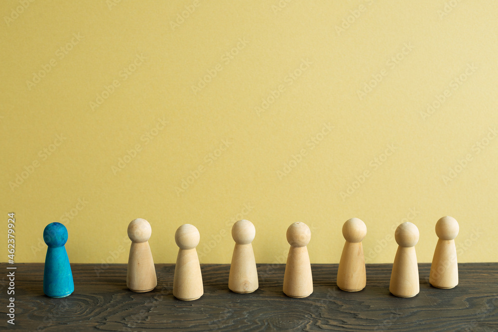 Majority vs minority concept. Wooden human figure on desk. brown background