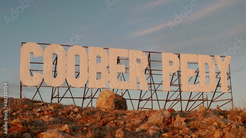 zoom in on a large metal sign with the words coober pedy on a hill at coober pedy in outback south australia photo
