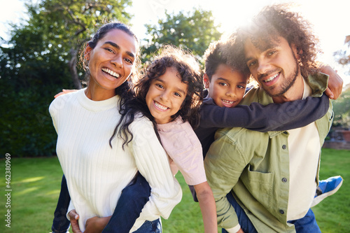 Portrait of family in garden smiling towards camera