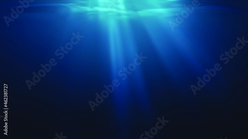 Sun rays and light shining through surface of ocean seen from underwater.