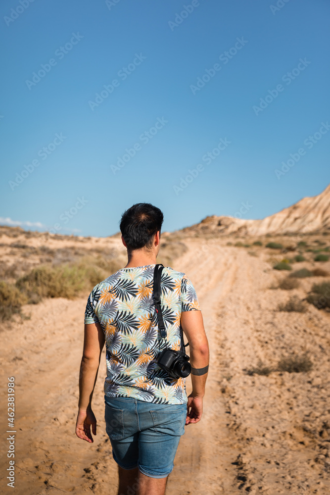 Naklejka premium Young man with a camera in Bardenas Reales desert, Navarra, Basque Country.