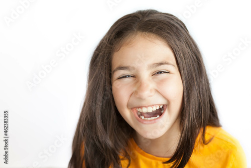 Portrait of happy smiling kid girl in yellow T-shirt isolated on white background © kaganskaya115