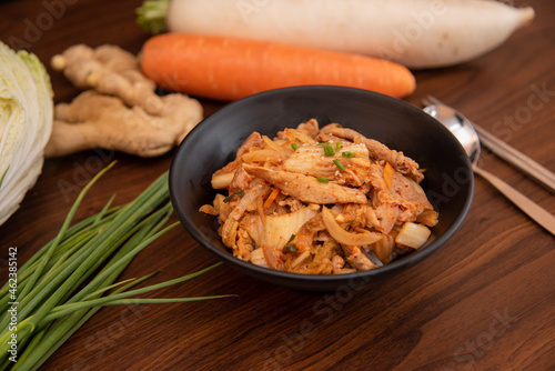 Stir fried kimchi with pork in a black bowl
