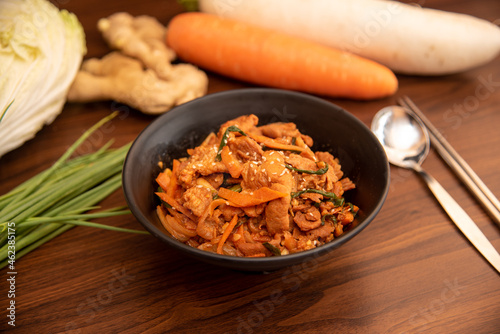 Stir fried kimchi with pork in a black bowl
