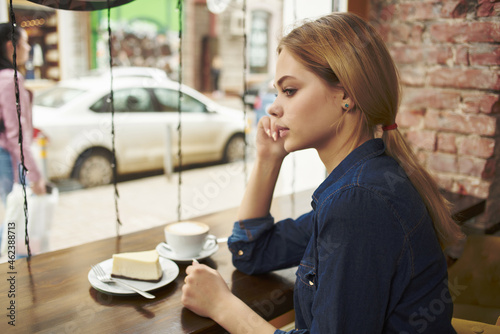 woman a cup of coffee in a cafe pensive look