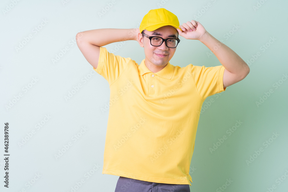 Young Asian delivery man posing on green background
