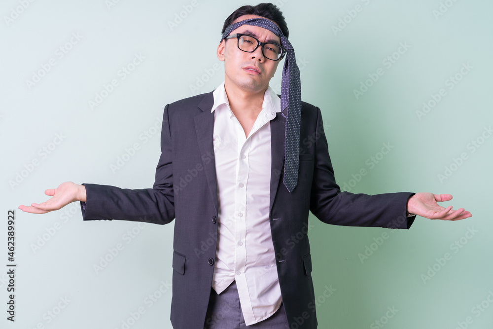 Young Asian businessman posing on green background Young Asian businessman posing on green background