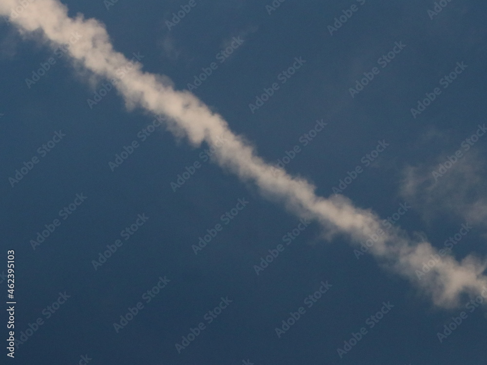White trail from an airplane in the blue sky White trail from an airplane in the blue sky