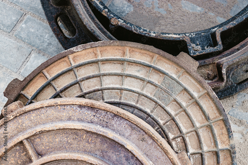 New cast iron manholes prepared for installation at the construction site. Hatches with covers lie on the paving slabs. New cast iron manholes prepared for installation at the construction site. Hatches with covers lie on the paving slabs.