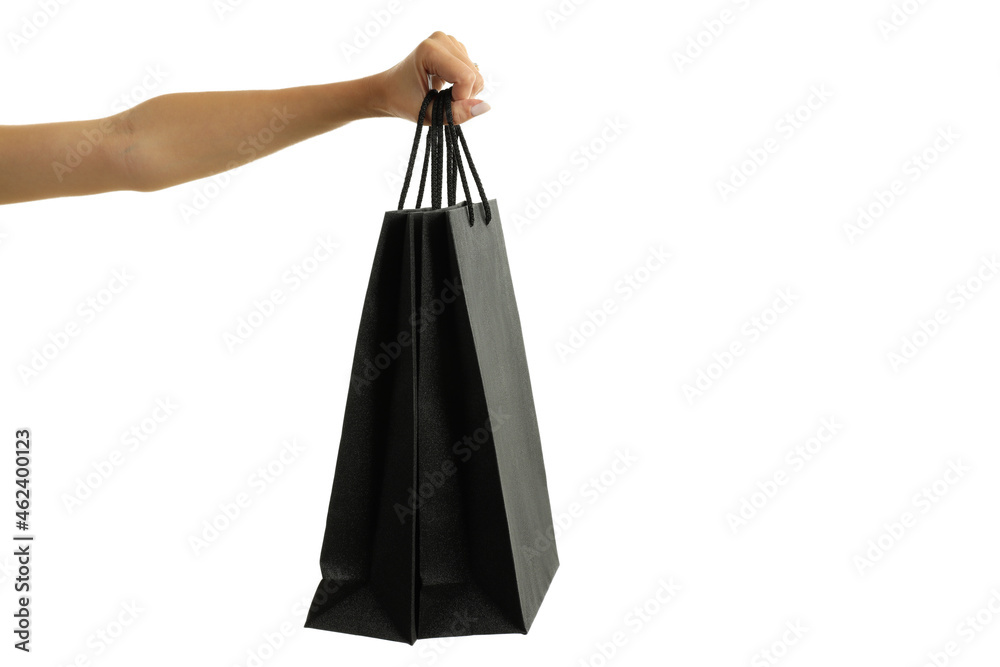 Female hand holds black paper bag, isolated on white background