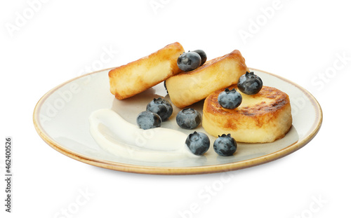 Plate with delicious cottage cheese pancakes, fresh blueberries and sour cream on white background