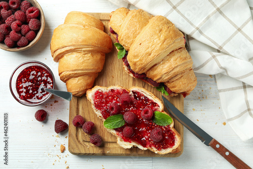Concept of delicious food with croissants with raspberry jam on white wooden background photo