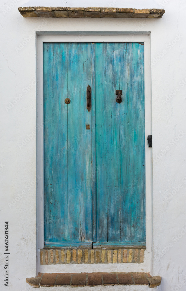 Beautiful door with turquoise wood and iron handle, knocker and doorbell in Vejer de la Frontera. Cadiz, Spain
