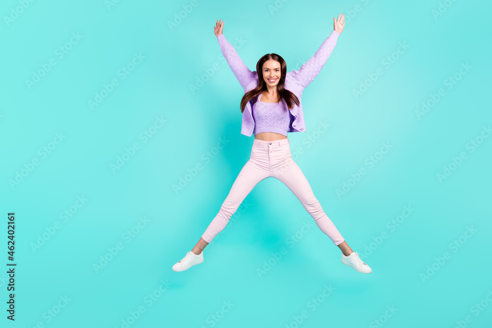 Photo of excited sweet young lady wear violet outfit smiling jumping high like star isolated turquoise color background