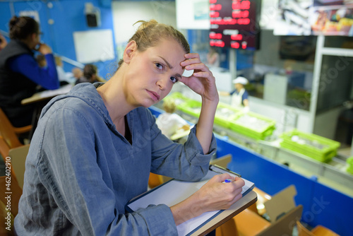 annoyed female clerk working in supermarket photo