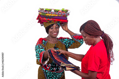 beautiful woman showing different traditional loincloths to a client while smiling.