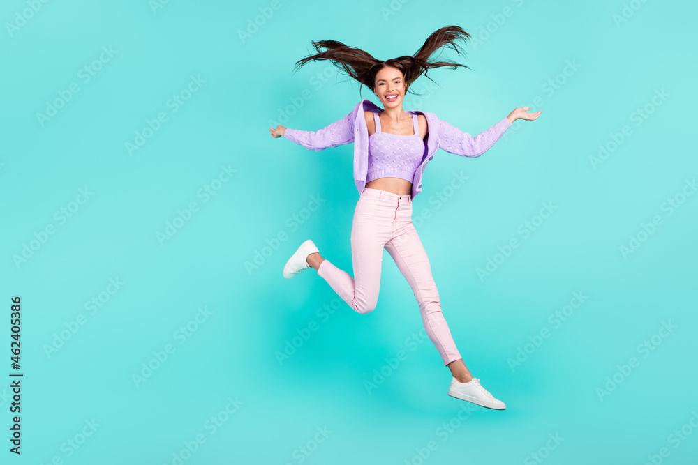 Photo of cute adorable young woman dressed purple clothes jumping high smiling isolated teal color background