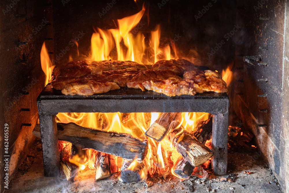 pork steaks preparing on the on a stone plate grill pork steaks preparing on the on a stone plate grill
