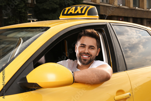 Valokuva Handsome taxi driver in car on city street
