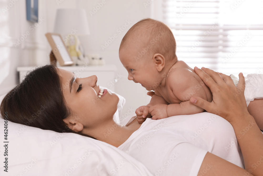 Happy young mother with her cute baby on bed at home Happy young mother with her cute baby on bed at home