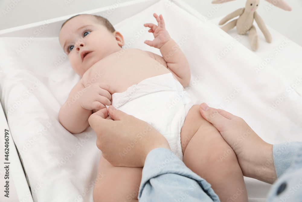 Mother changing baby's diaper, focus on hands Mother changing baby's diaper, focus on hands