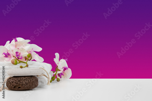 Beautiful pink flowers and white towels on pink background