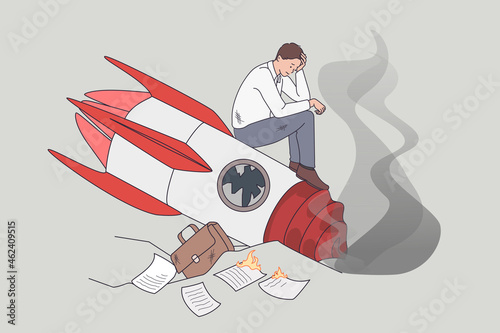 Failed and crashed business rocket startup. Vector concept illustration of sad business manager standing on broken launching missile.