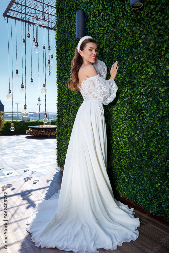 Fototapeta premium Sexy beautiful brunette woman pretty bride wedding big day marriage ceremony in summer garden wearing long silk and lace white dress bright makeup hairstyle pure love interior.