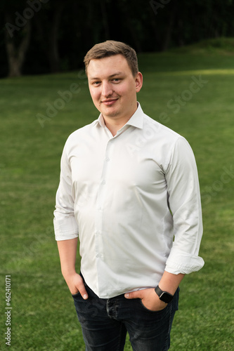 close-up of a man in a white shirt who walks in the park in the summer. contented man of European appearance