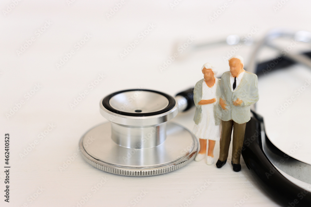 Miniature people near a stethoscope. Concept of insurance and health - obrazy, fototapety, plakaty 