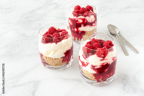 Raspberry Cheesecake Dessert in Glasses on White Marble