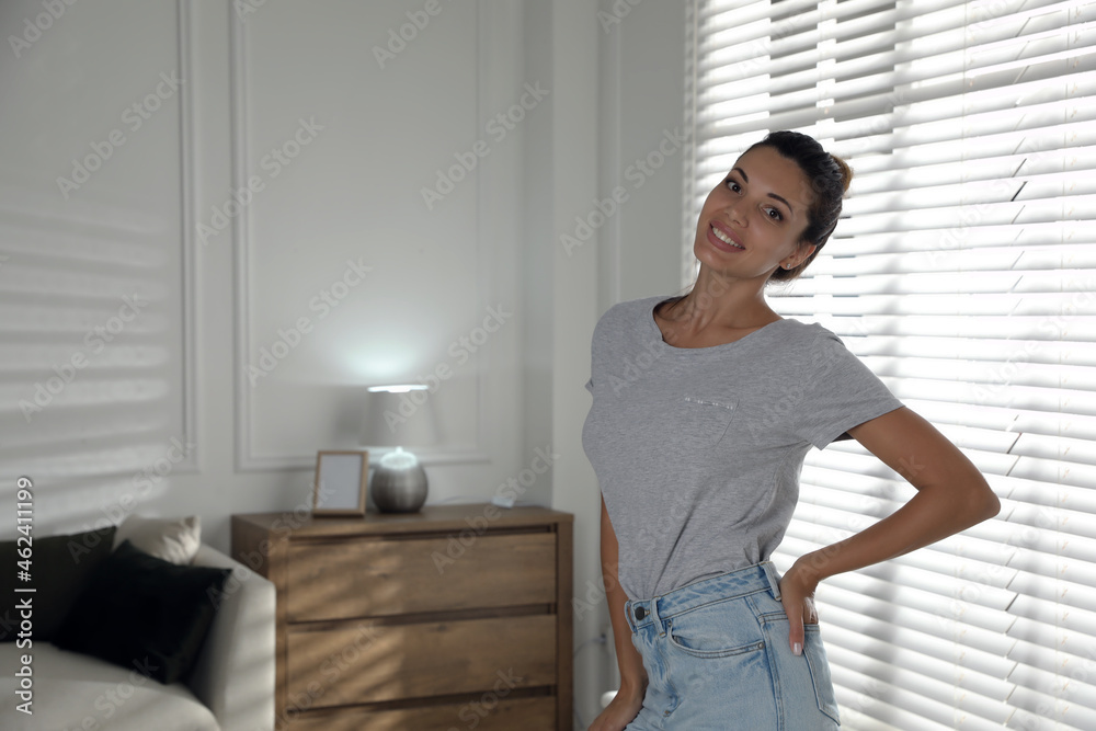 Portrait of beautiful woman near window at home, space for text Portrait of beautiful woman near window at home, space for text