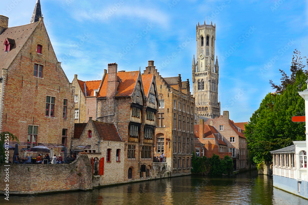 view of the famous dijver canal with historic buildings alongside the watercourse and view of the belfry tower in the center of bruges, Flanders, belgium view of the famous dijver canal with historic buildings alongside the watercourse and view of the belfry tower in the center of bruges, Flanders, belgium